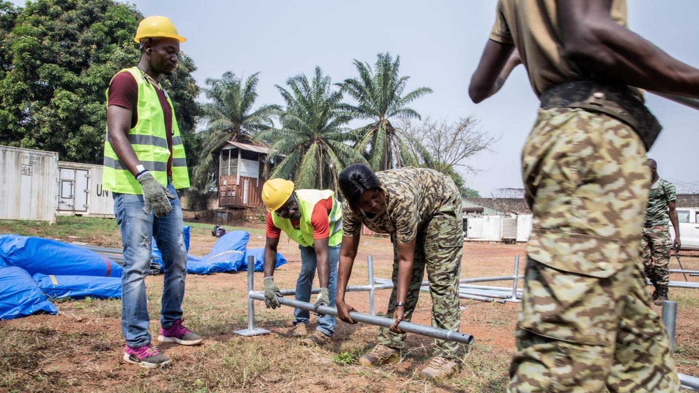 four people making a tent