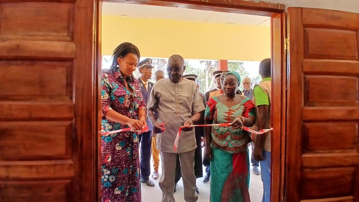 Deux femmes et un homme coupent un ruban à l'entrée d'un nouveau bâtiment